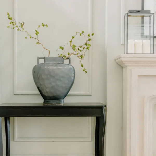 Two stems of twisted willow create a beautiful and impactful shape thats works in conversation with the striking urn